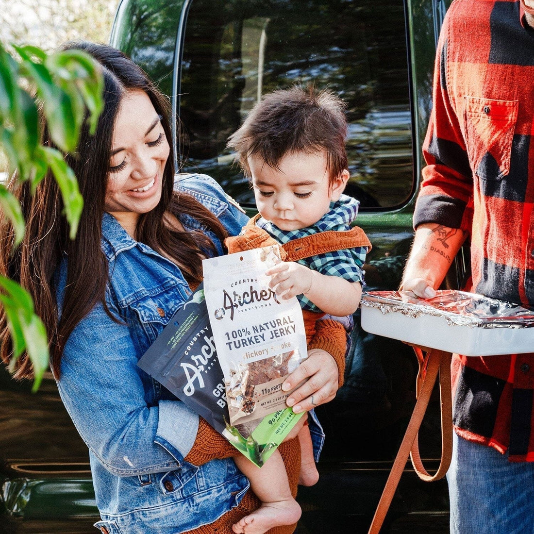 young mom with a baby and a package of archer turkey jerky