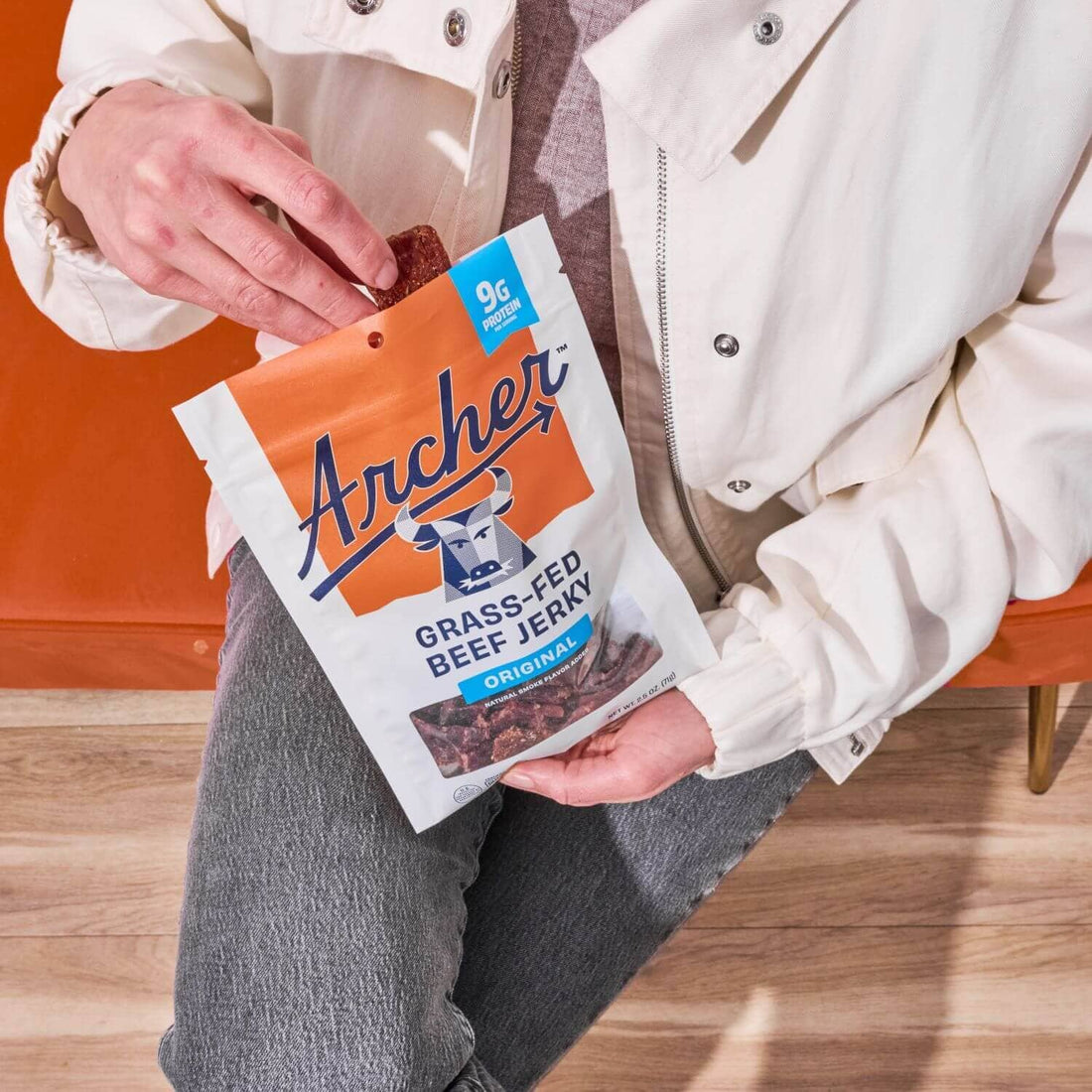Man pulling archer beef jerky from a bag.